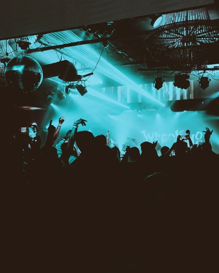 Concert crowd with cyan stage lighting at Photo City Music Hall