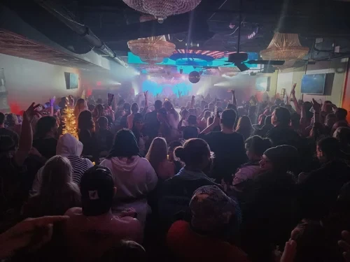 Packed crowd at Photo City Music Hall with colorful stage lighting